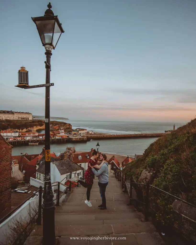 travel couple on 199 steps in whitby at sunrise